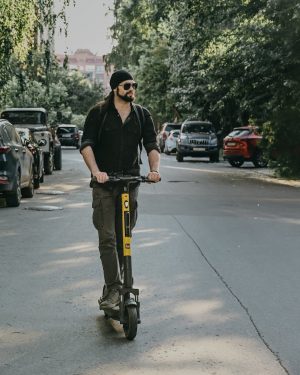 a man riding an electric scooter on the road